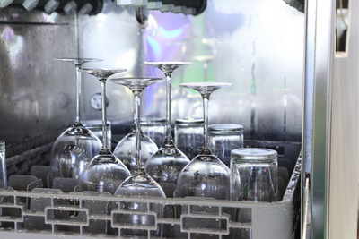 Verres mouillés qui reposent dans un lave-verres professionnel.