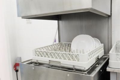 Lave-vaisselle à capot contenant de la vaisselle propre grâce à un récupérateur de déchets.